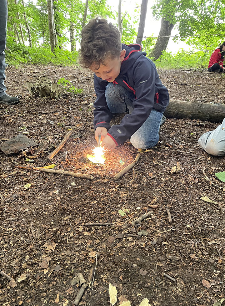 Little boy is delighted to learn how to start a fire