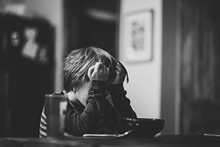 Boy appearing distressed while tring to work